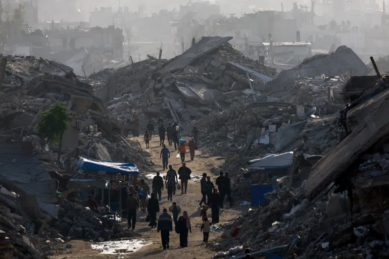 Palestinians walk among piles of rubble in the northern Gaza Strip Palestinians walk among piles of rubble in the northern Gaza Strip