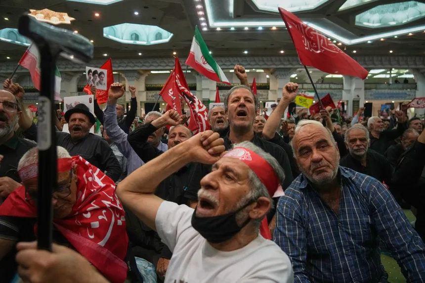 Mourners chant, fists raised, during a gathering commemorating the late Supreme Leader Ali Khamenei at the Imam Khomeini Mosalla Grand Mosque in Tehran